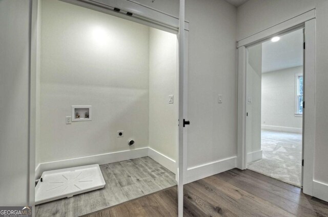 clothes washing area featuring wood finished floors, baseboards, hookup for an electric dryer, laundry area, and washer hookup