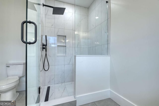 bathroom featuring tile patterned flooring, toilet, baseboards, and walk in shower