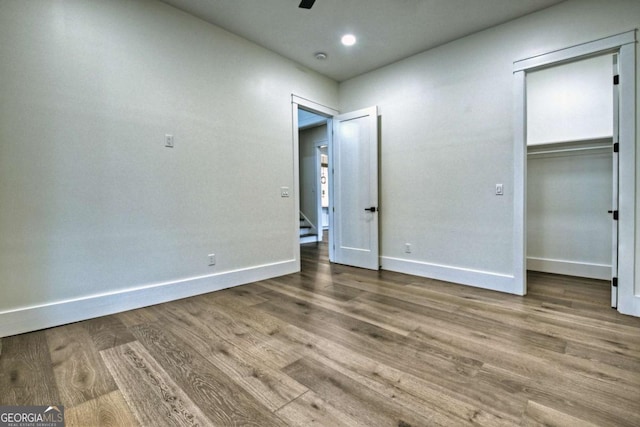 unfurnished bedroom with a closet, baseboards, and wood finished floors