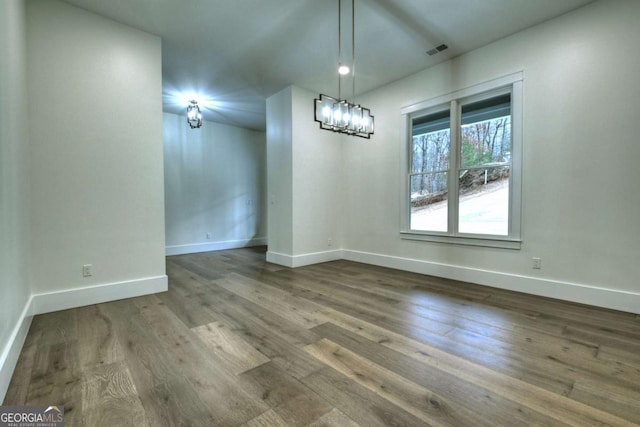 unfurnished dining area featuring visible vents, baseboards, and wood finished floors