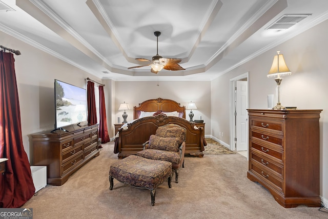 carpeted bedroom with a tray ceiling, ceiling fan, and crown molding