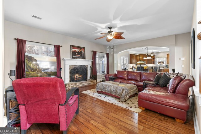 living room with a fireplace, hardwood / wood-style flooring, and ceiling fan