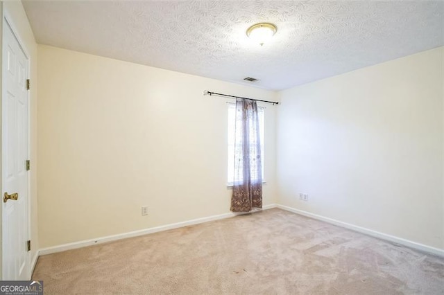 carpeted spare room featuring a textured ceiling