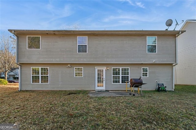 rear view of house with a patio area and a lawn