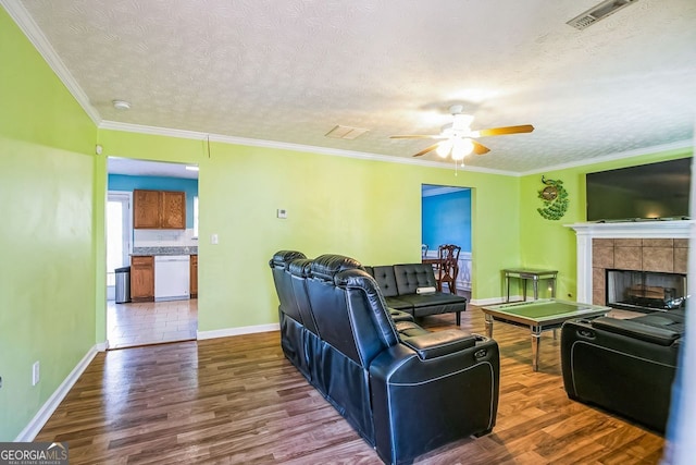 living room with a textured ceiling, wood-type flooring, and crown molding