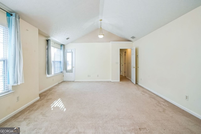 carpeted spare room with lofted ceiling