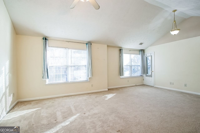 unfurnished room featuring light colored carpet, a wealth of natural light, lofted ceiling, and ceiling fan