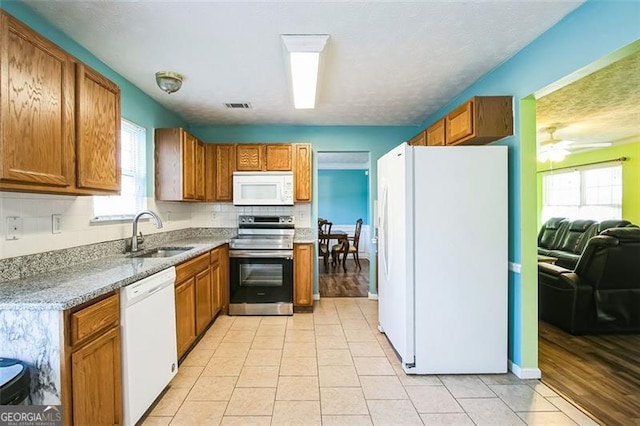 kitchen featuring ceiling fan, sink, light tile patterned floors, and white appliances