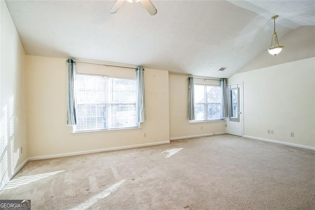 carpeted empty room with plenty of natural light, ceiling fan, and lofted ceiling