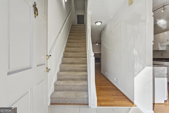 stairway with wood-type flooring and rail lighting