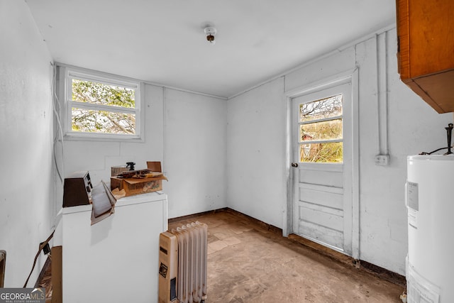 interior space featuring radiator heating unit, a wealth of natural light, and water heater