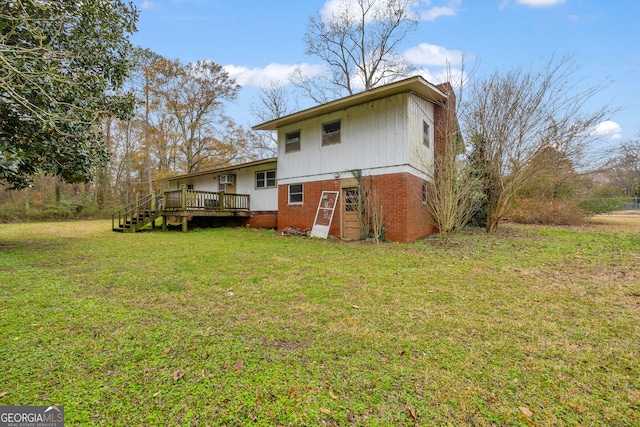 rear view of property with a yard and a deck