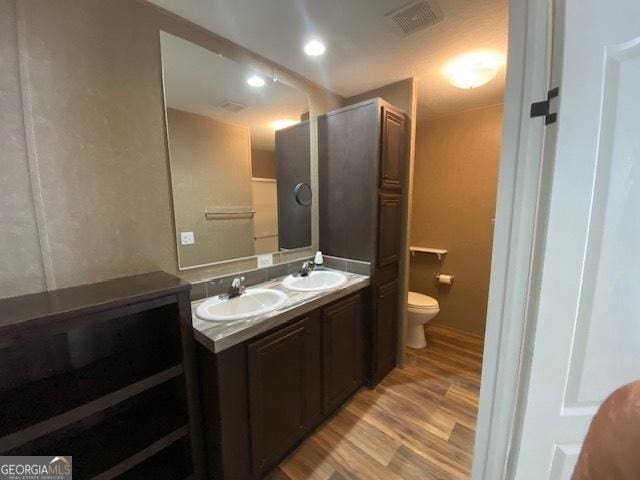 bathroom featuring toilet, vanity, and hardwood / wood-style flooring