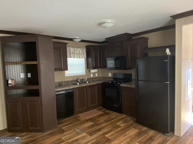 kitchen featuring dark brown cabinetry, dark wood-type flooring, black appliances, and sink