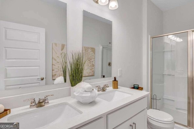 bathroom featuring vanity, toilet, and a shower with shower door