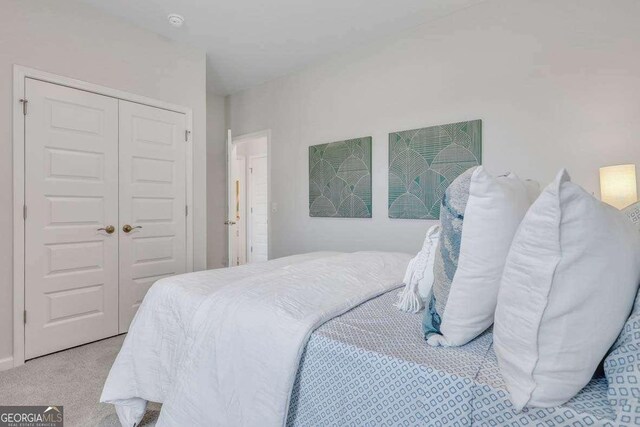 bedroom featuring light carpet and a closet