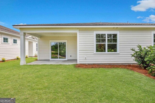 back of property featuring a patio area and a yard