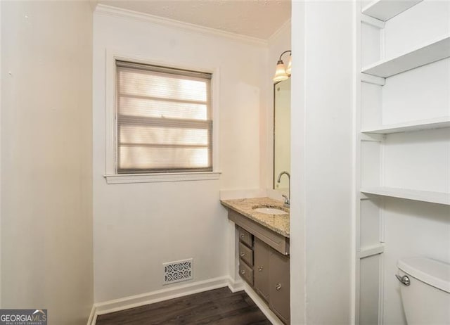 bathroom featuring hardwood / wood-style floors, vanity, toilet, and crown molding