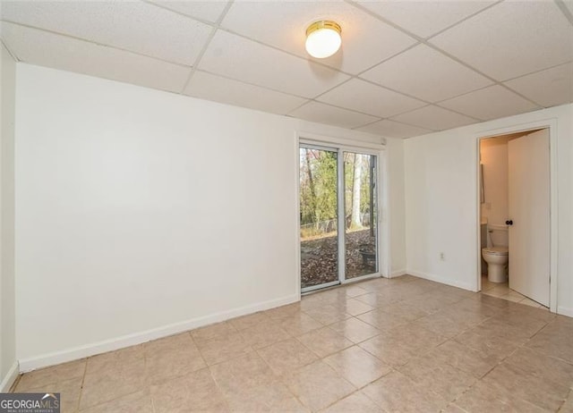 empty room featuring a drop ceiling and light tile patterned floors