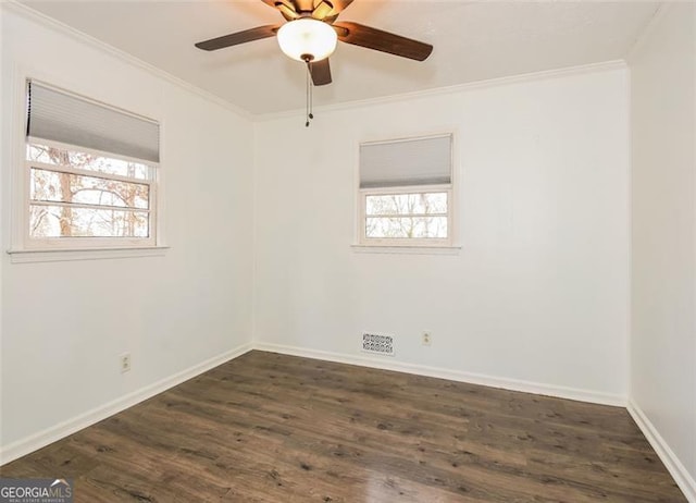 unfurnished room featuring dark wood-type flooring, a healthy amount of sunlight, and ornamental molding