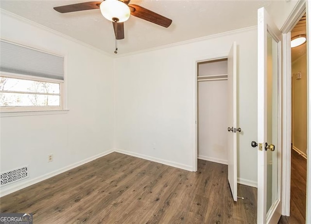 unfurnished bedroom featuring a closet, ceiling fan, crown molding, and dark hardwood / wood-style floors