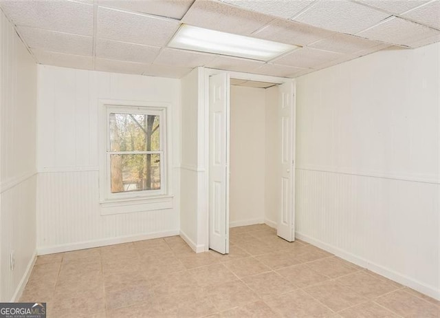 basement with a paneled ceiling