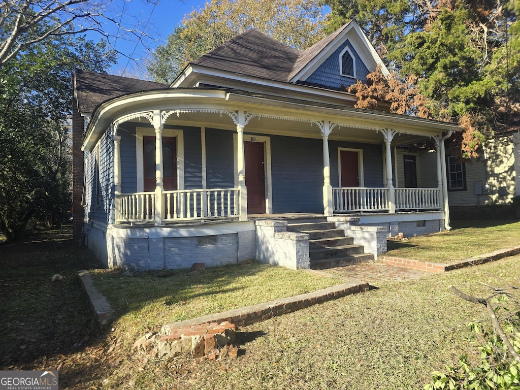 view of front of property with covered porch and a front yard