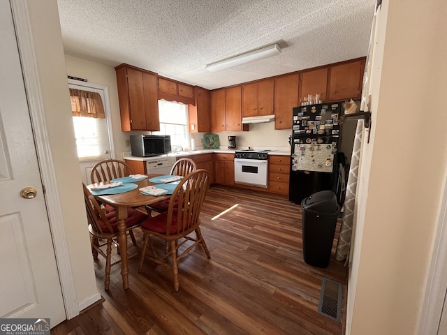 kitchen with sink, black appliances, dark hardwood / wood-style floors, and a textured ceiling