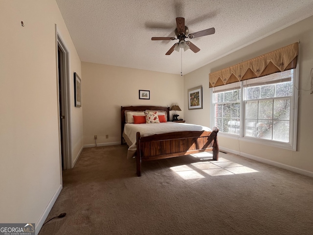 bedroom with ceiling fan, a textured ceiling, and dark carpet