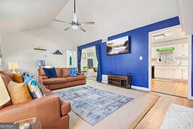 living room with ceiling fan, sink, light hardwood / wood-style floors, and vaulted ceiling