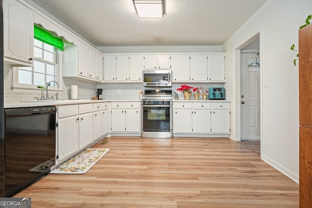 kitchen with backsplash, sink, white cabinets, and appliances with stainless steel finishes