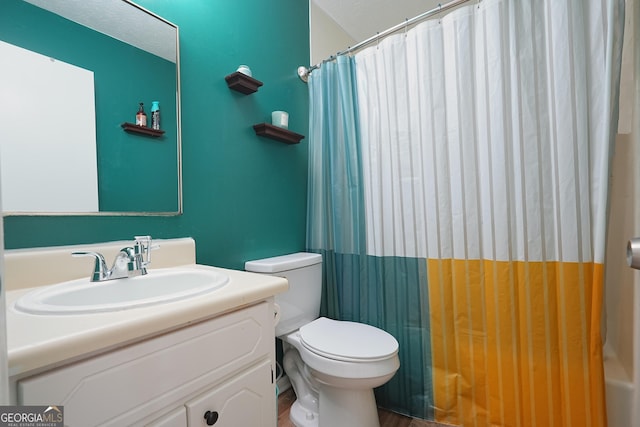 bathroom featuring vanity, toilet, and curtained shower