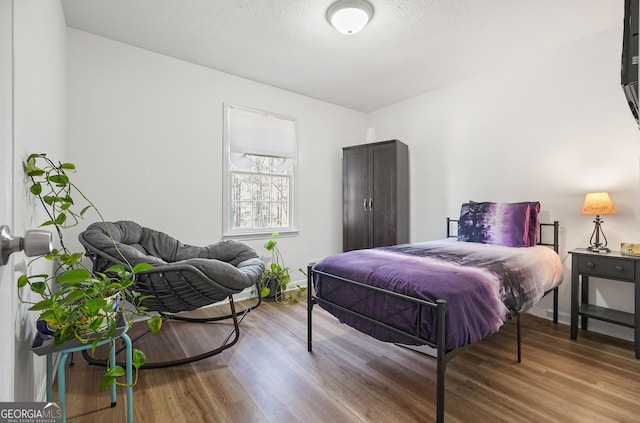 bedroom with hardwood / wood-style floors and a textured ceiling