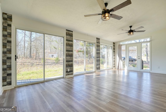 unfurnished sunroom with ceiling fan and a healthy amount of sunlight