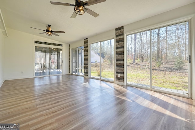 unfurnished sunroom with plenty of natural light, lofted ceiling, and ceiling fan