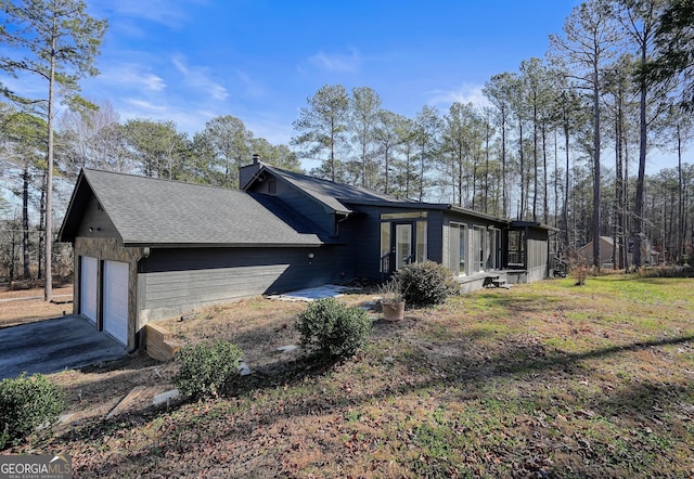 view of side of home with a lawn and a garage