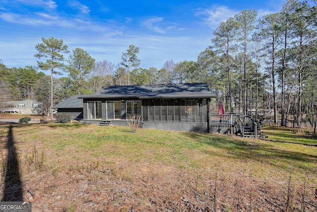 back of house featuring a lawn and a sunroom