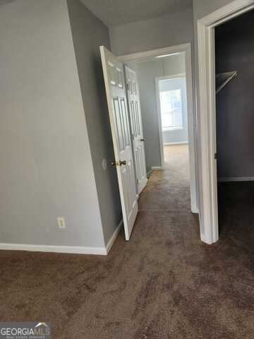 hallway with dark colored carpet