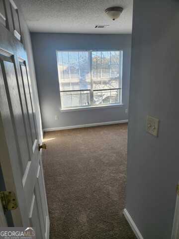 carpeted empty room with a textured ceiling