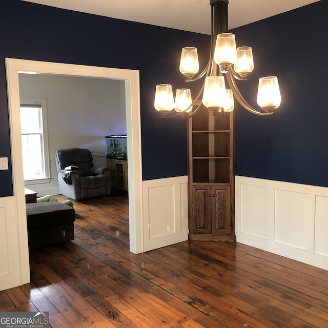 dining room with dark hardwood / wood-style flooring and a notable chandelier