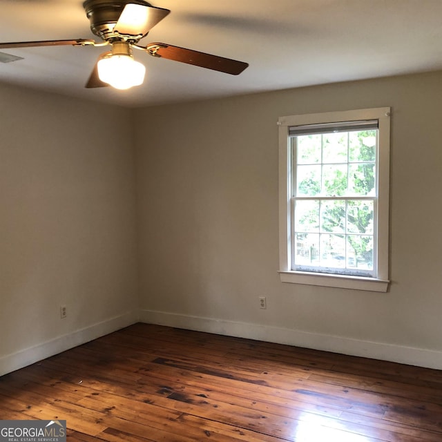 spare room featuring dark hardwood / wood-style flooring and ceiling fan