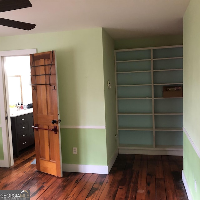 hall featuring built in shelves and dark hardwood / wood-style flooring