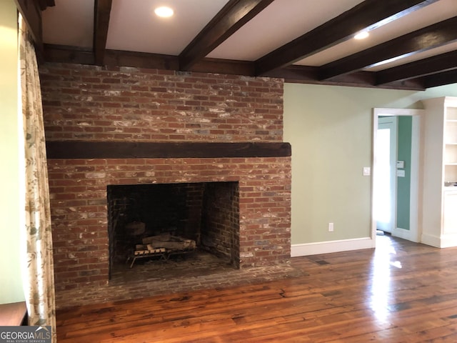 details with beam ceiling, wood-type flooring, and a brick fireplace