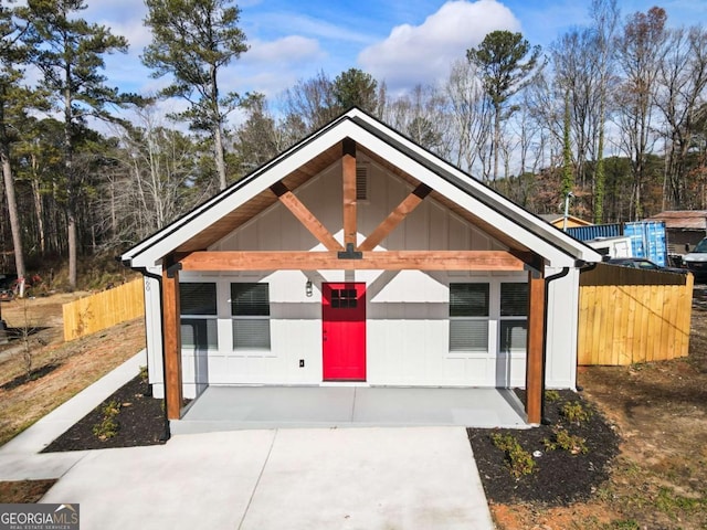 view of front of house featuring board and batten siding and fence