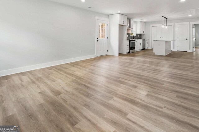 living area featuring visible vents, light wood finished floors, attic access, and recessed lighting