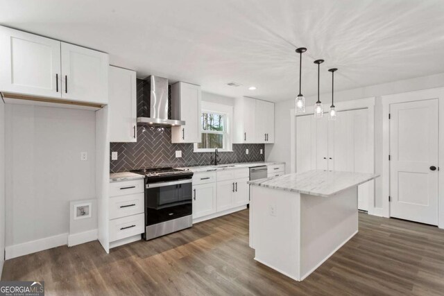 kitchen featuring light stone counters, dark wood-style flooring, decorative light fixtures, stainless steel range with electric cooktop, and white cabinetry