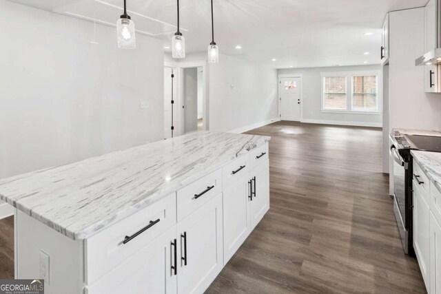 kitchen with a sink, a center island, white cabinets, hanging light fixtures, and light stone countertops