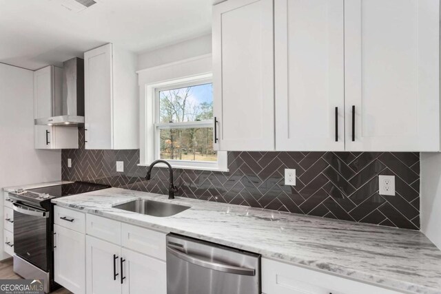 kitchen featuring pendant lighting, white cabinetry, a kitchen island, a sink, and light stone countertops