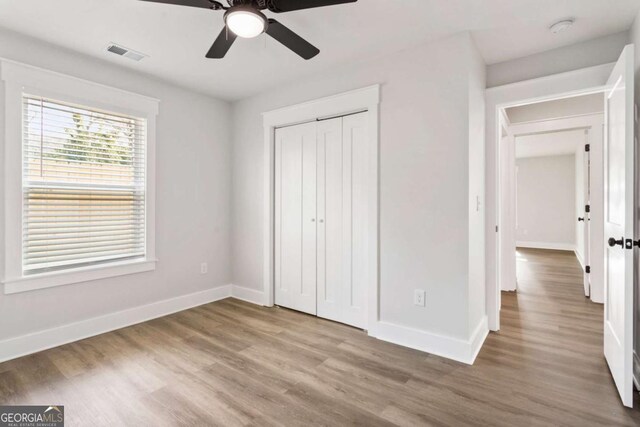 spare room featuring light wood-style flooring, visible vents, baseboards, and ceiling fan