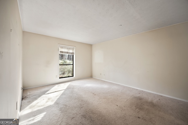 unfurnished room featuring a textured ceiling and light colored carpet